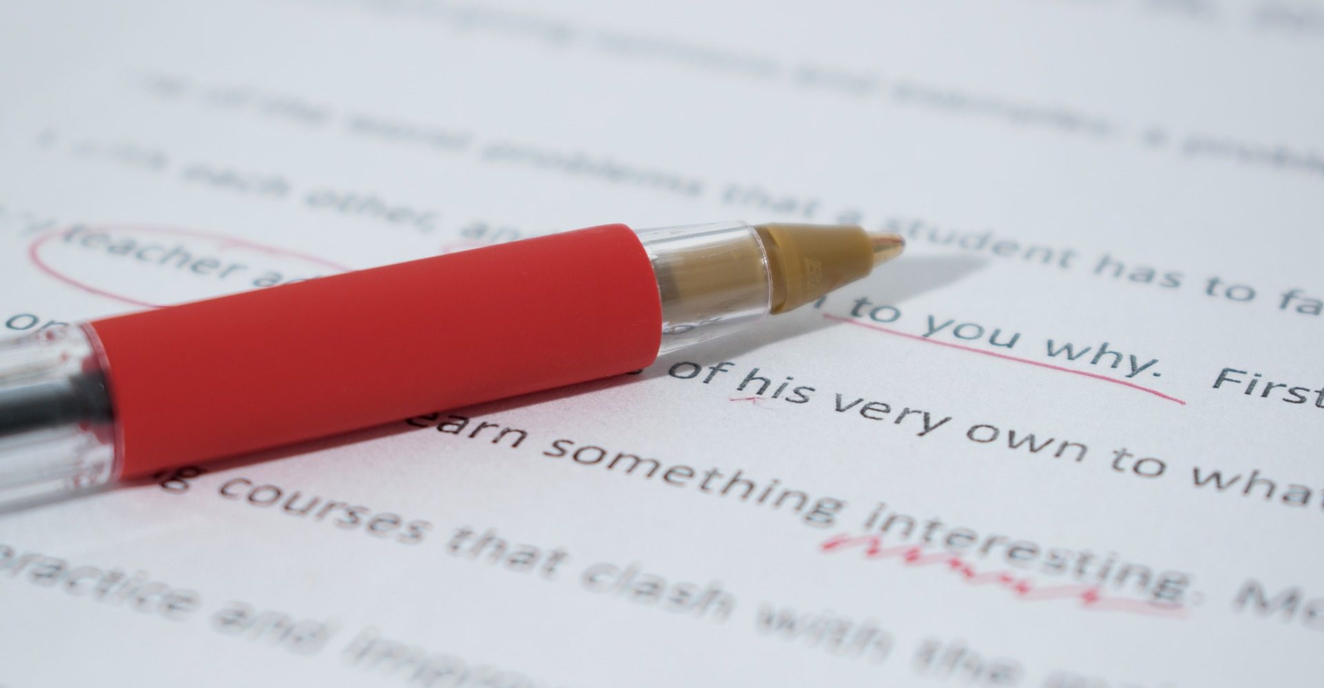 A red pen on a document with some mistakes which have been corrected