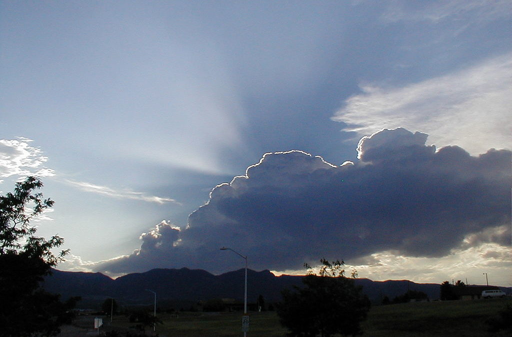 a dark cloud illuminated by the sun, creating a visible edge around the cloud: a silver lining
