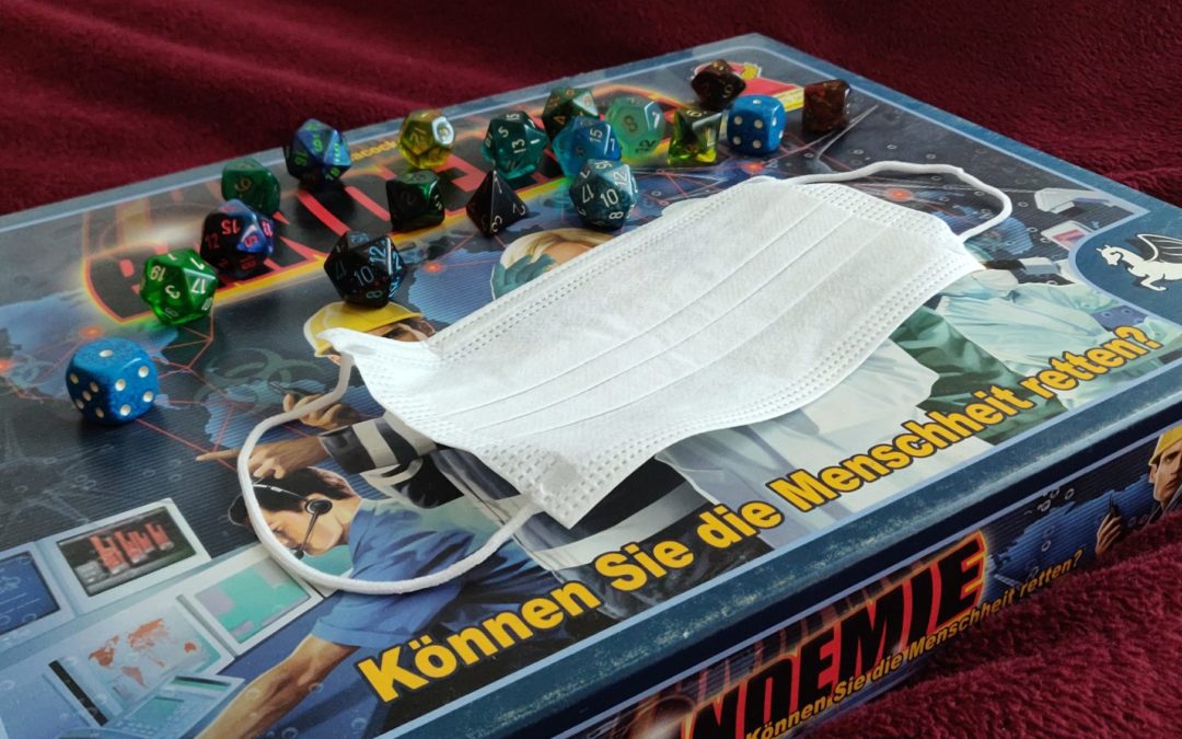 A photo of a board game in a box with the German title "Pandemie". On the box there are some dice and a face mask
